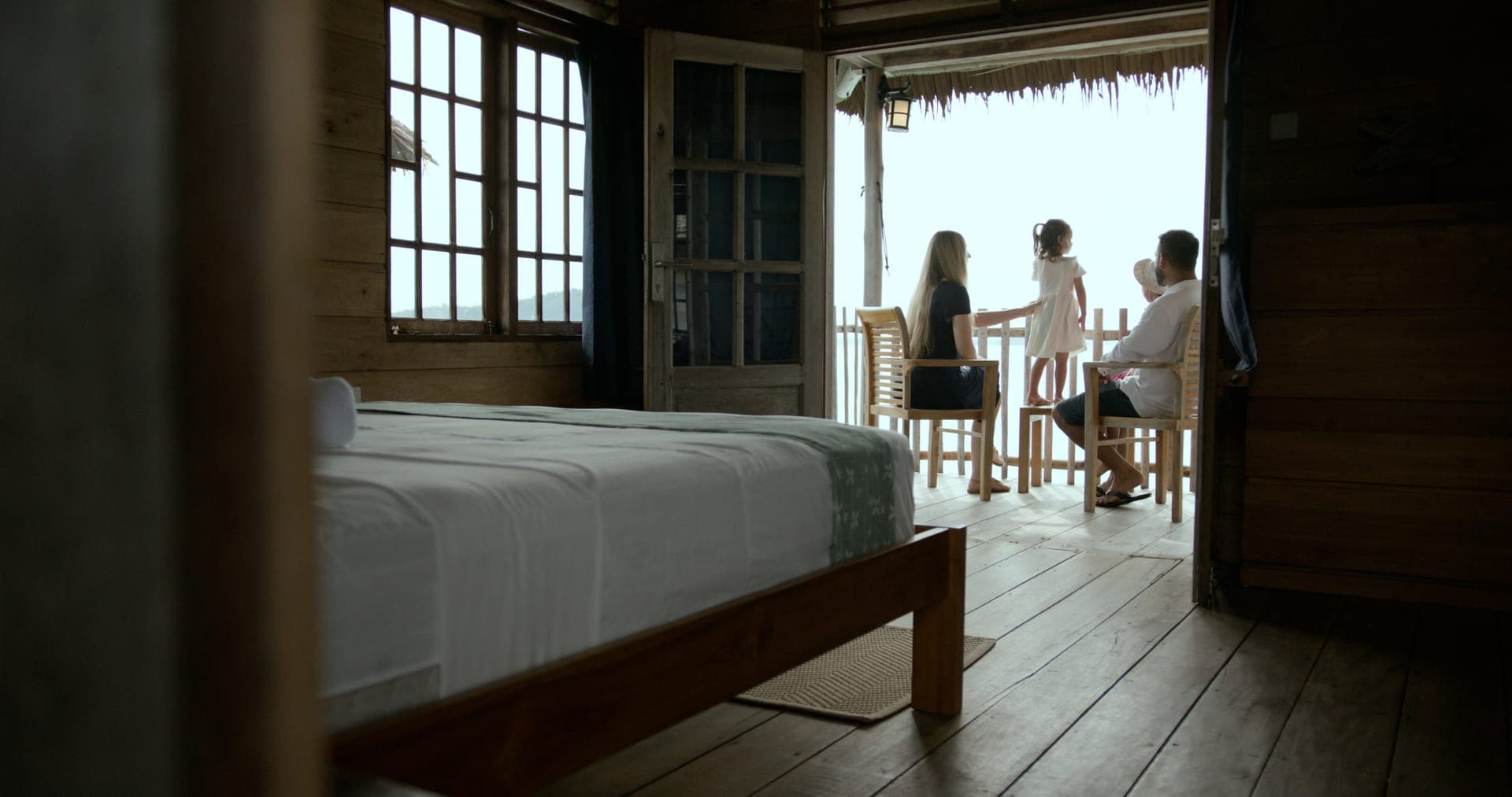 Family relaxing on an overwater bungalow balcony at Telunas Beach Resort