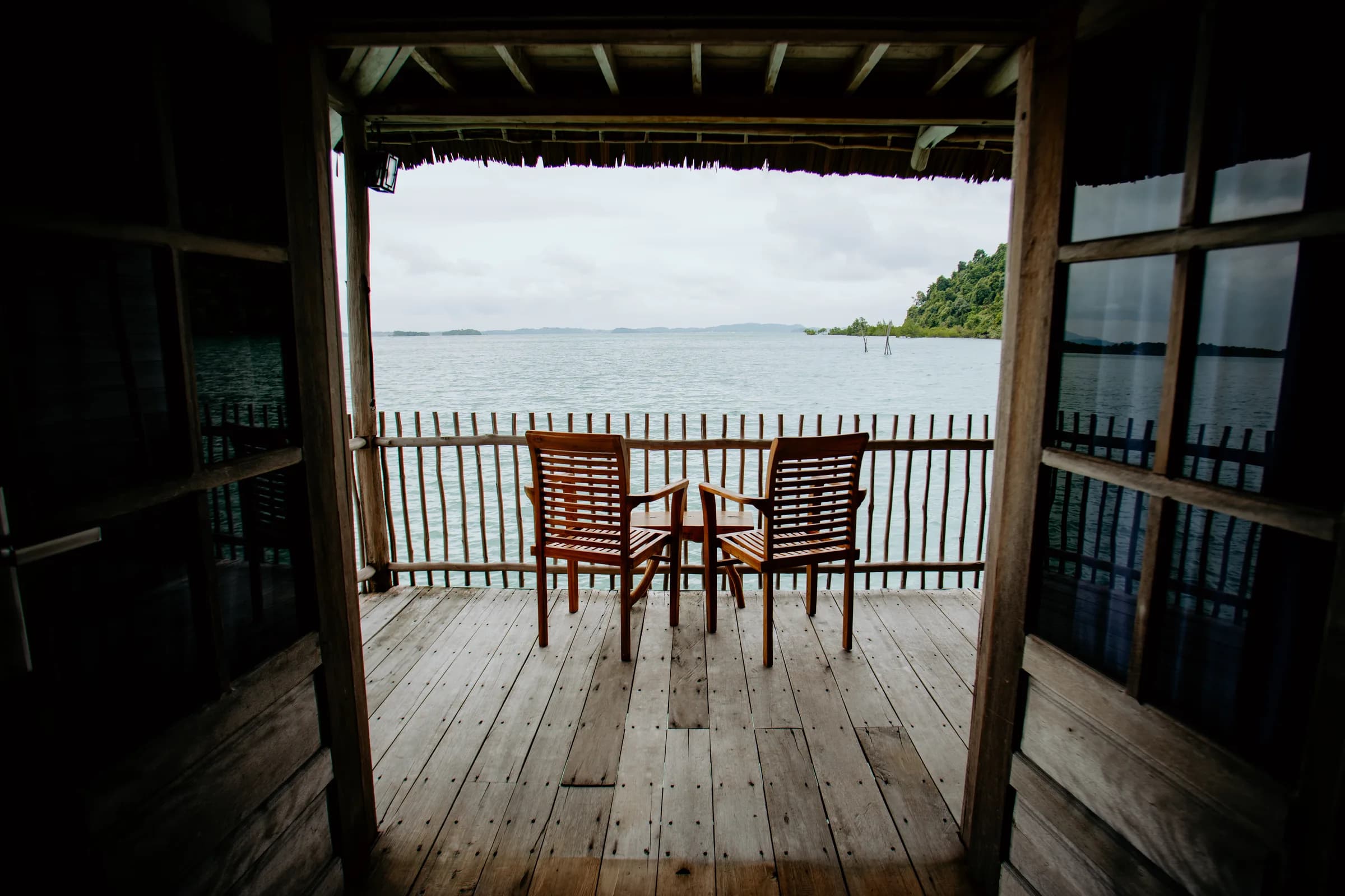 Private balcony with Adirondack chairs over the water at an Overwater Bungalow with Balcony, Telunas Beach Resort