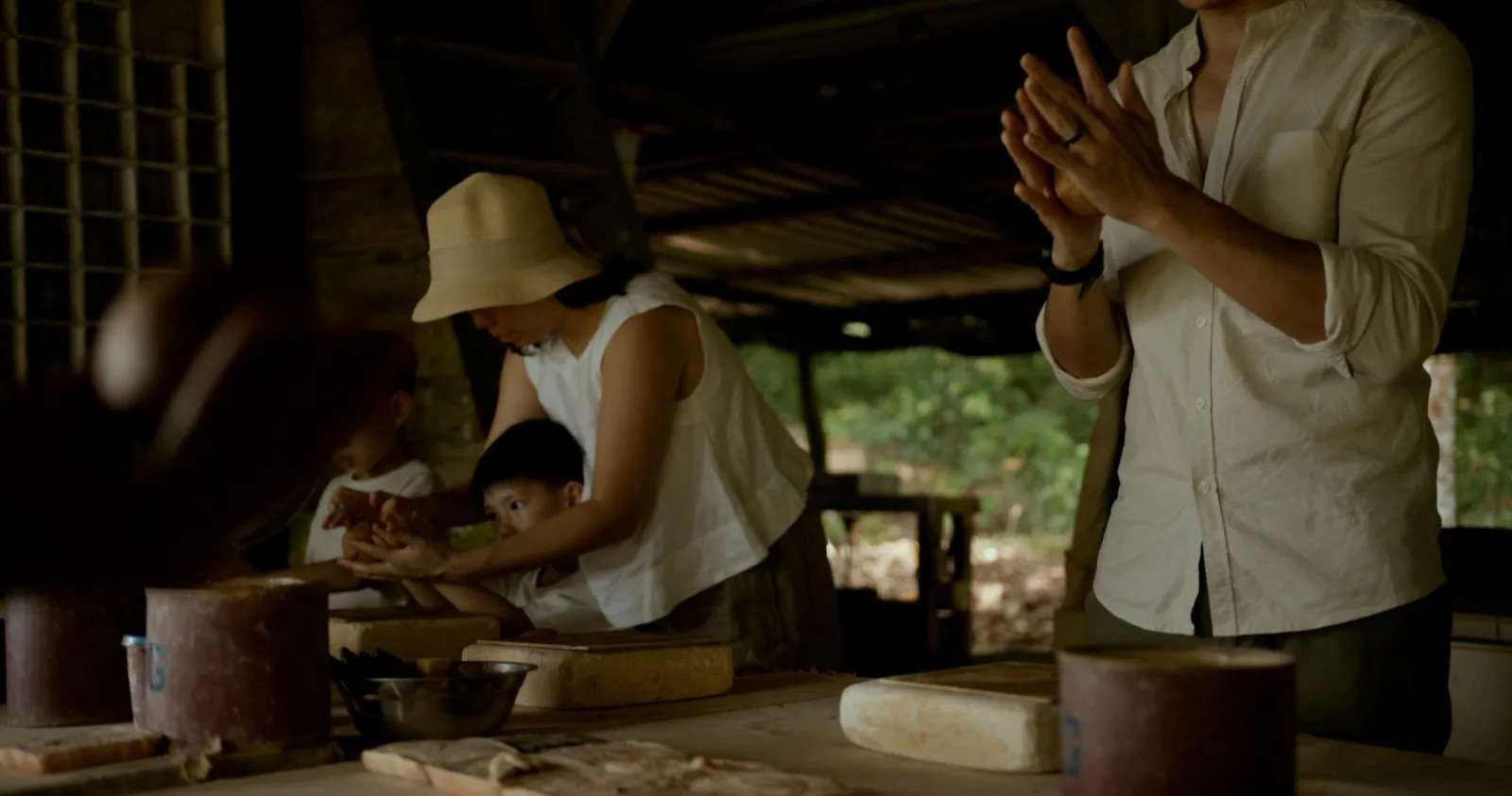Children and adults working with clay during a pottery activity at Telunas.