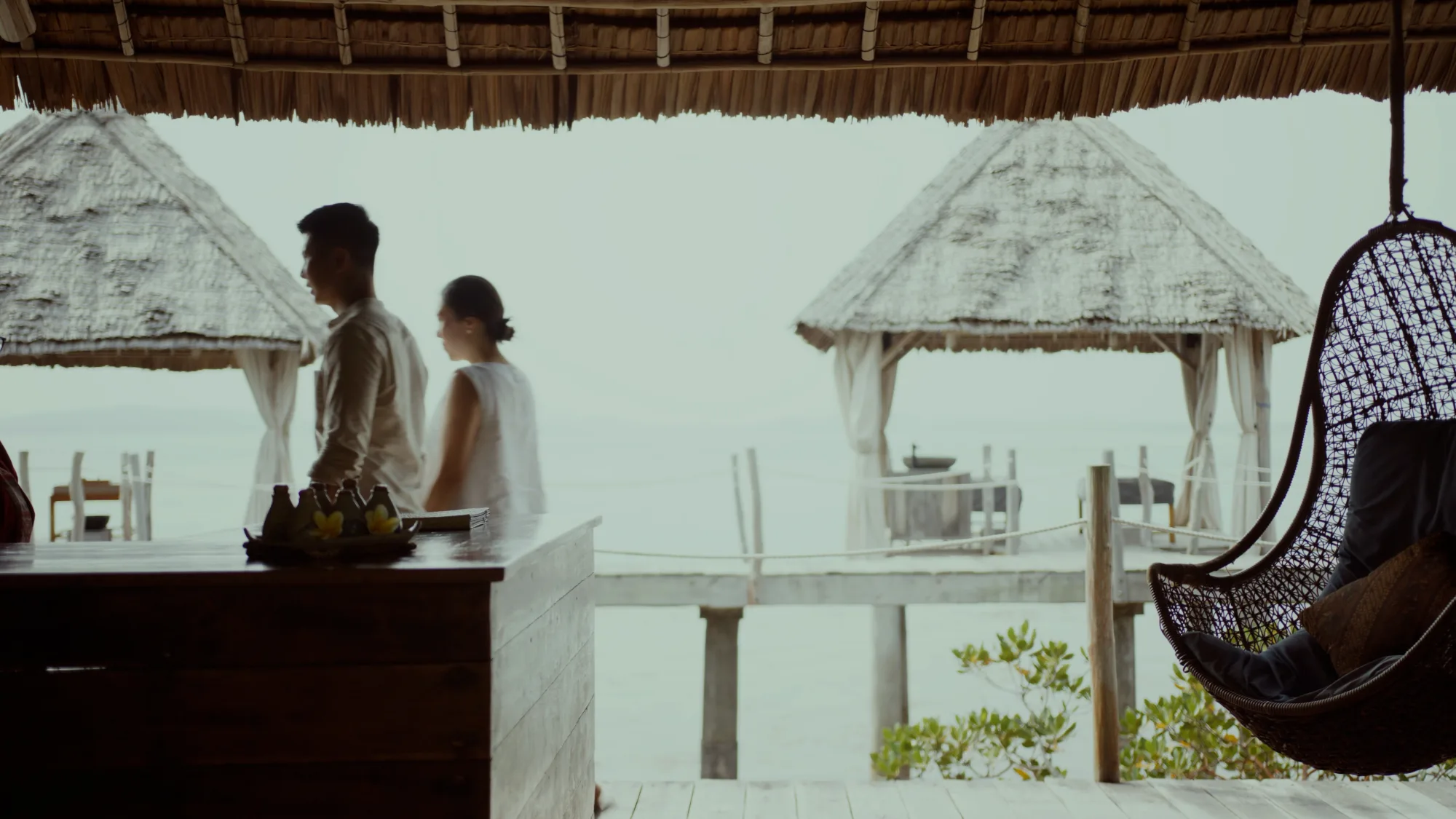 Couple walking past the Overwater Massage pavilion at Telunas Private Island
