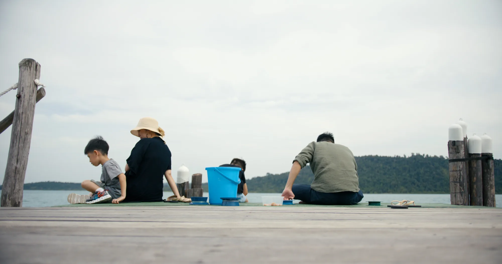 A family fishing together from the jetty at Telunas Private Island.