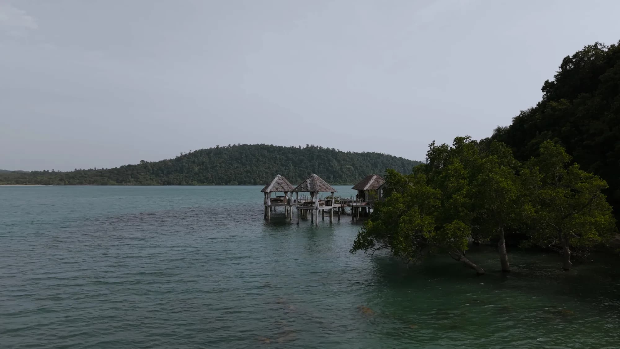 Aerial view of the overwater massage pavilions at Telunas Private Island, surrounded by turquoise water and mangroves