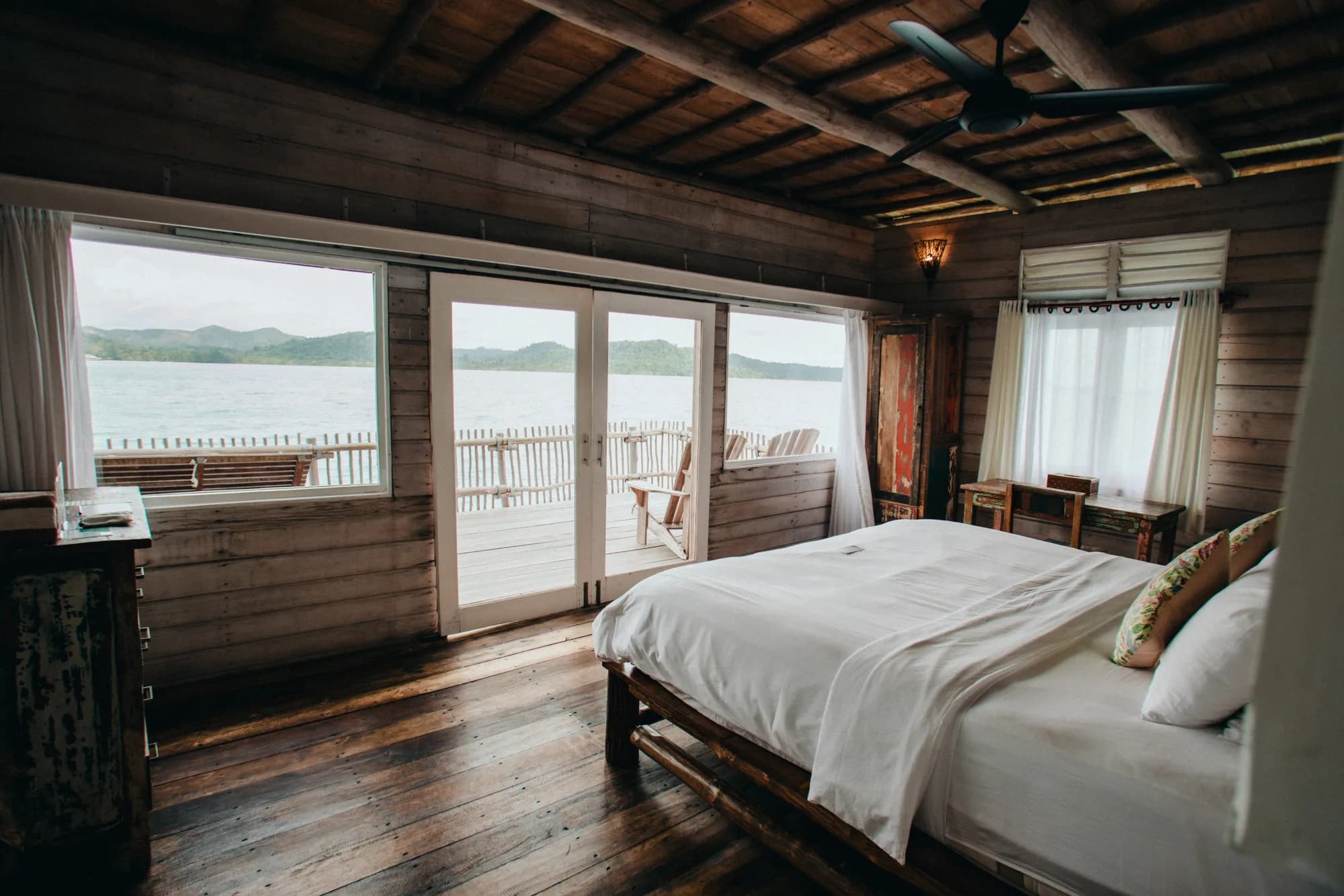 Overwater Villa bedroom with balcony and water views at Telunas Private Island